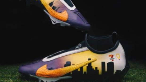 Side view of Dorian Singer's custom purple and orange Nike cleats.